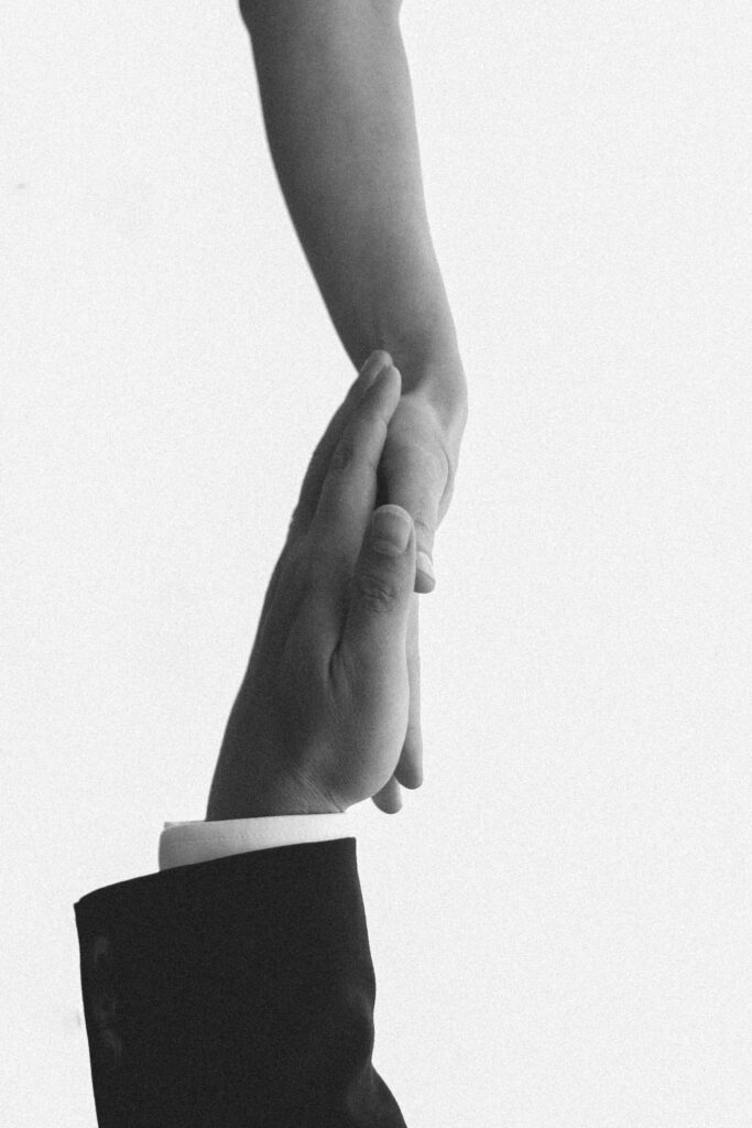 A monochrome image of hands reaching out, symbolizing connection and support.